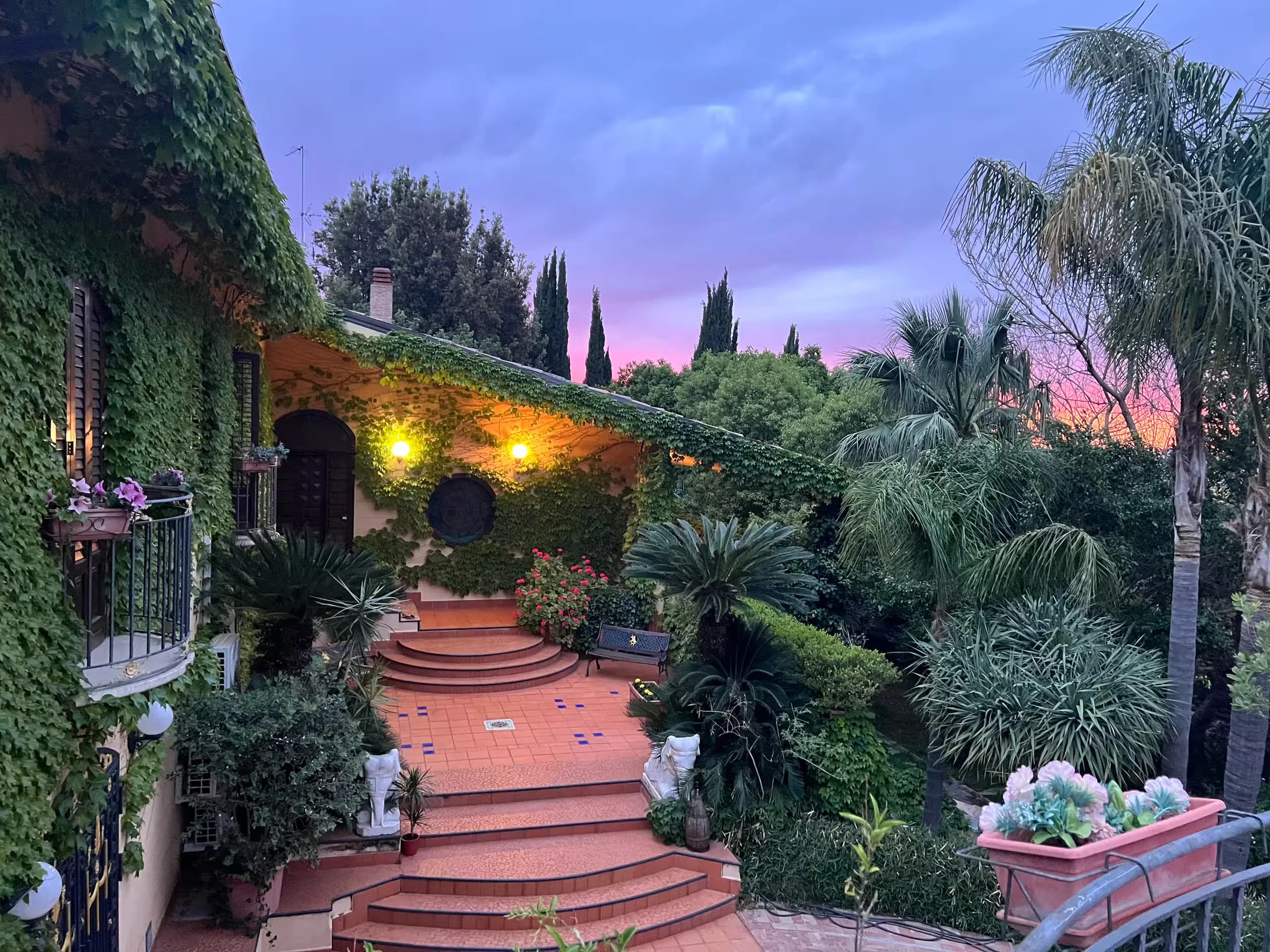 The house at dusk, seen from the tiled garden steps